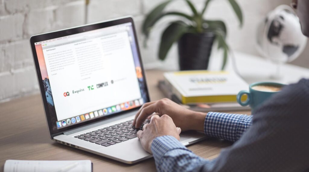 Person browsing the internet on a MacBook for online protection