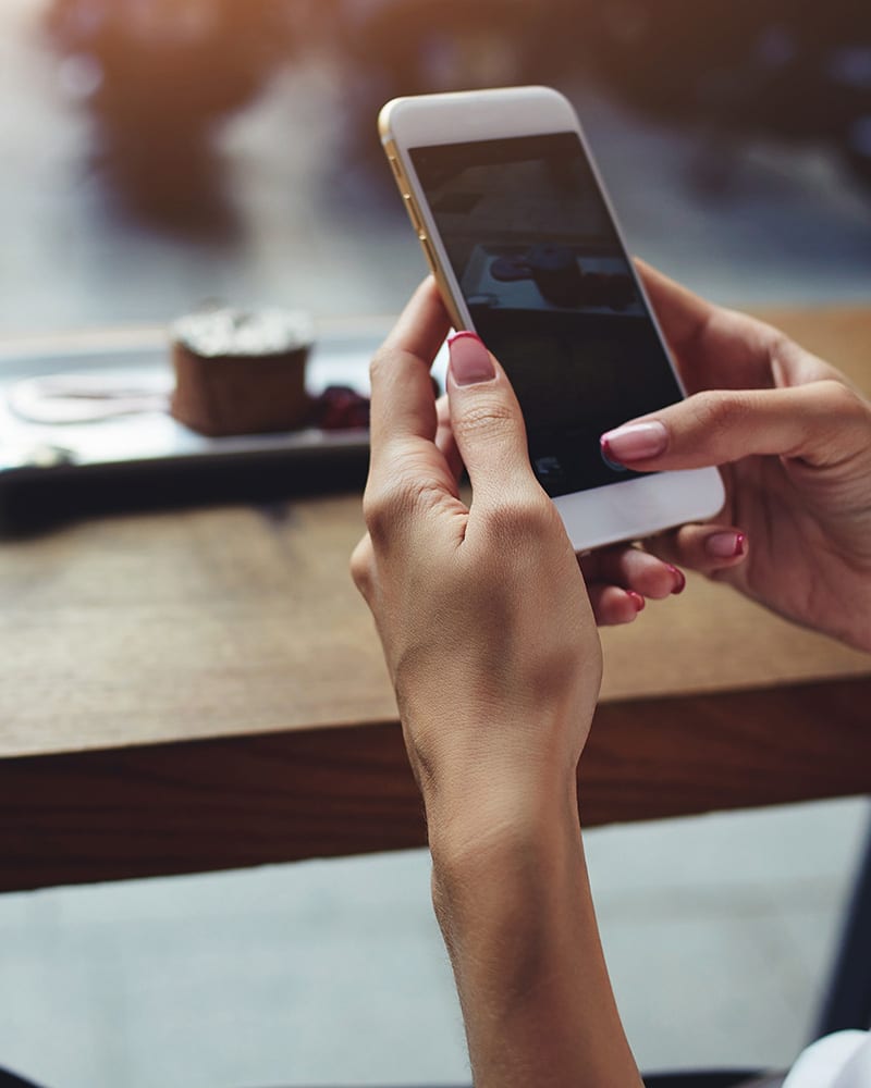 Person hooding mobile phone and typing