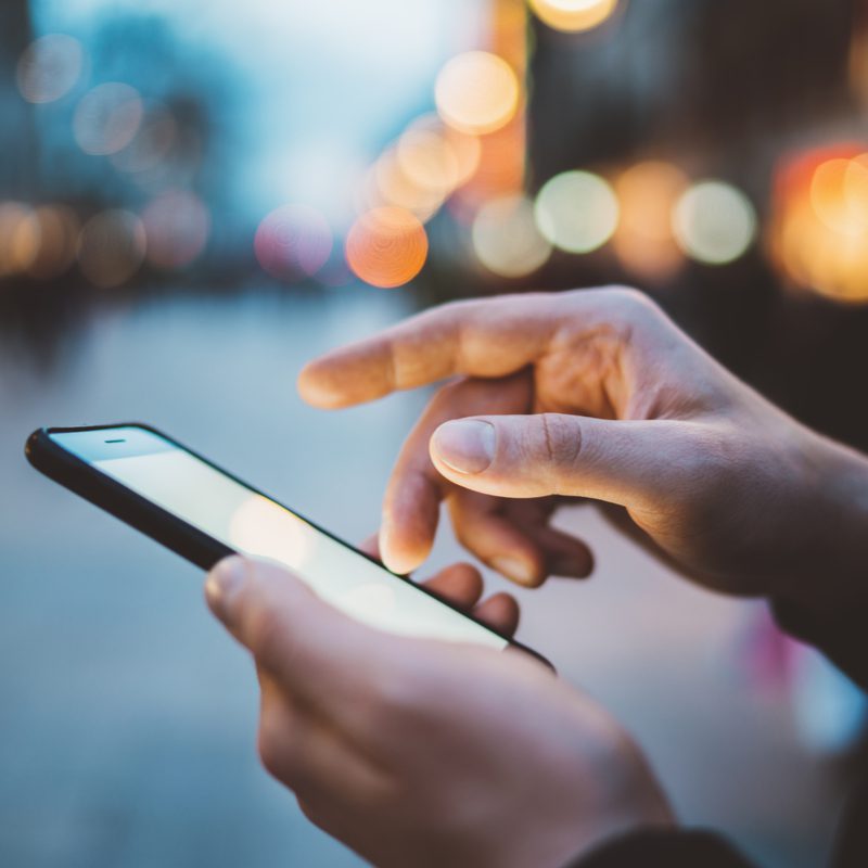 Person using mobile phone for accurate mobile number cleansing