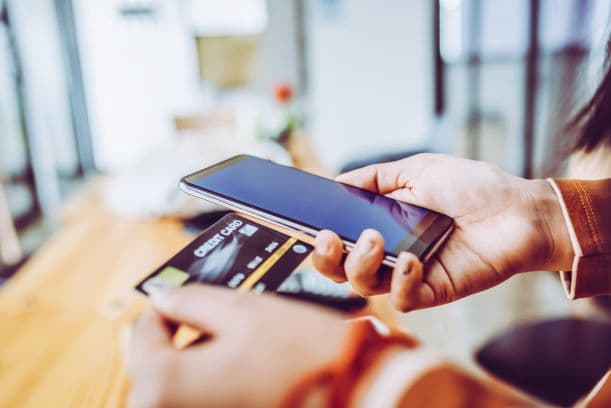 Person holding a bank card and mobile phone using kyc verification technology