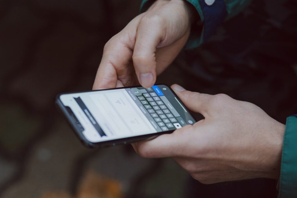 Person texting on a mobile phone for mobile number intelligence for onboarding