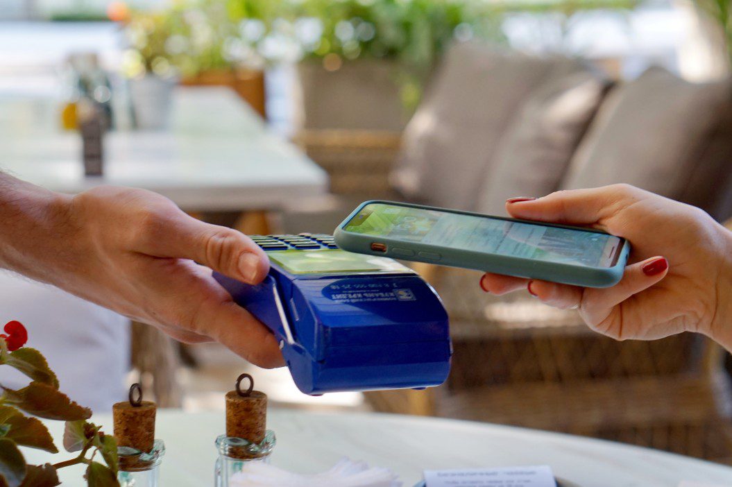 téléphone mobile utilisant apple pay pour le paiement dans un restaurant montrant la vérification numérique kyc