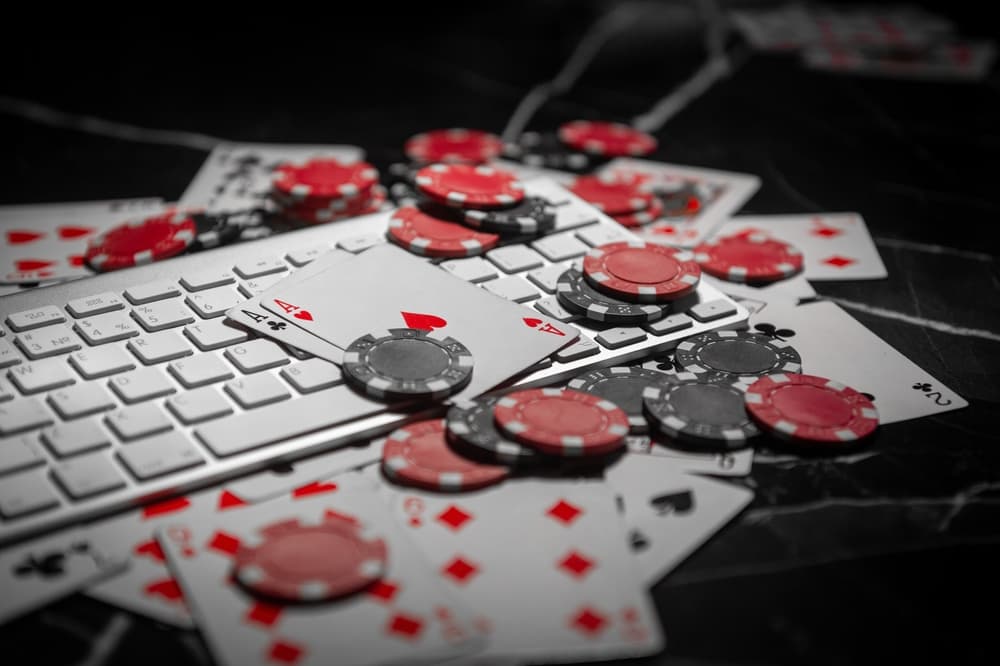 Poker chips and playing cards next to a keyboard